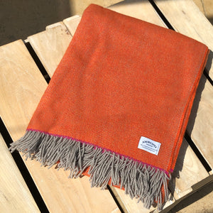 Orange wool throw folded on a box