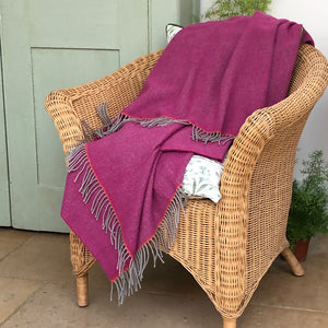 Pink wool blanket thrown on a wicker chair
