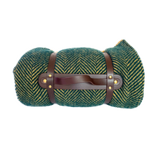 Carry handle on a green herringbone wool picnic blanket with waterproof backing