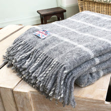 grey blanket folded up on a coffee table