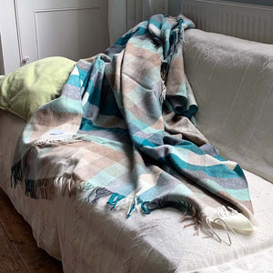 Harlequin merino wool throw draped on a sofa