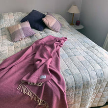 Pink merino lambswool throw on the end of a bed