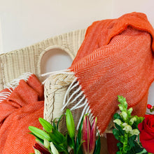 Orange herringbone wool blanket in a chair