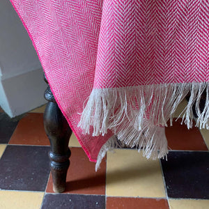Tassels on the edge of a pink linen throw