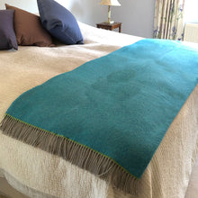 Turquoise blue wool throw on a double bed