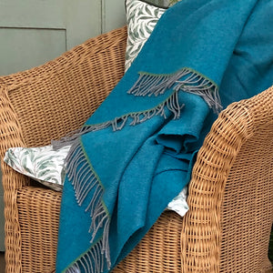 Turquoise wool interior throw on a wicker chair