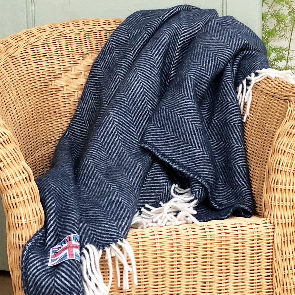 navy blue herringbone throw draped over a wicker chair