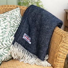 dark blue herringbone throw folded over a conservatory chair